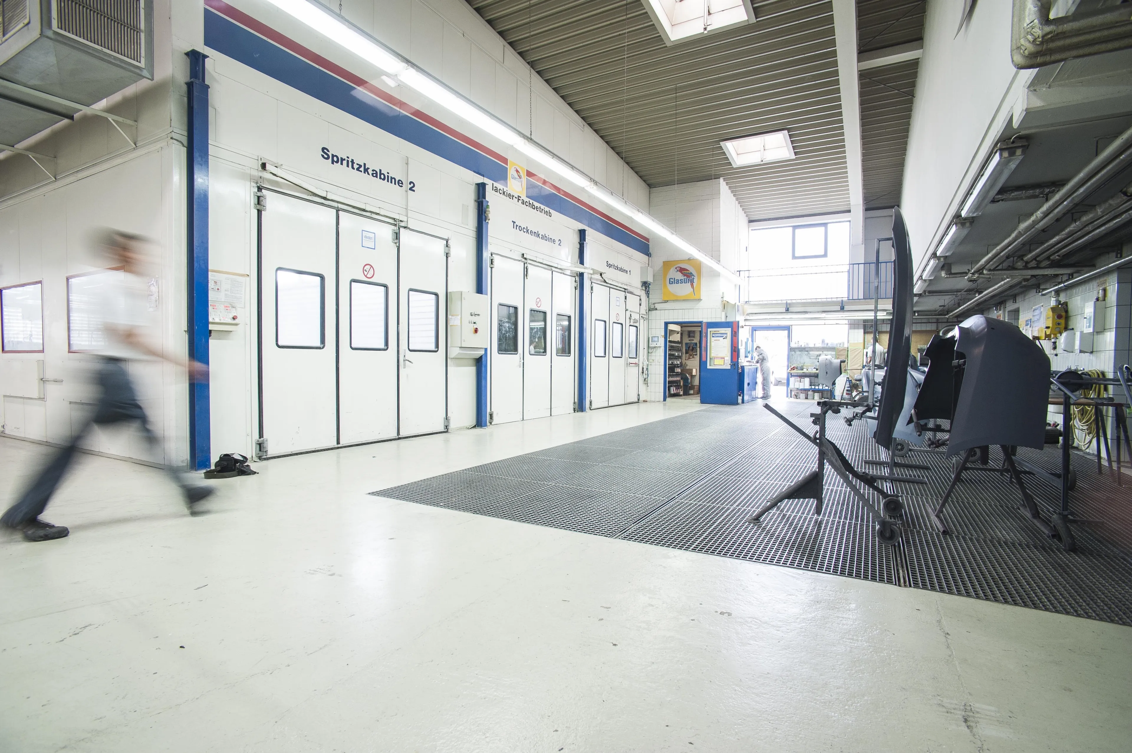 Zu den drei Spitzkabinen läuft ein Mitarbeiter schnell durchs Bild