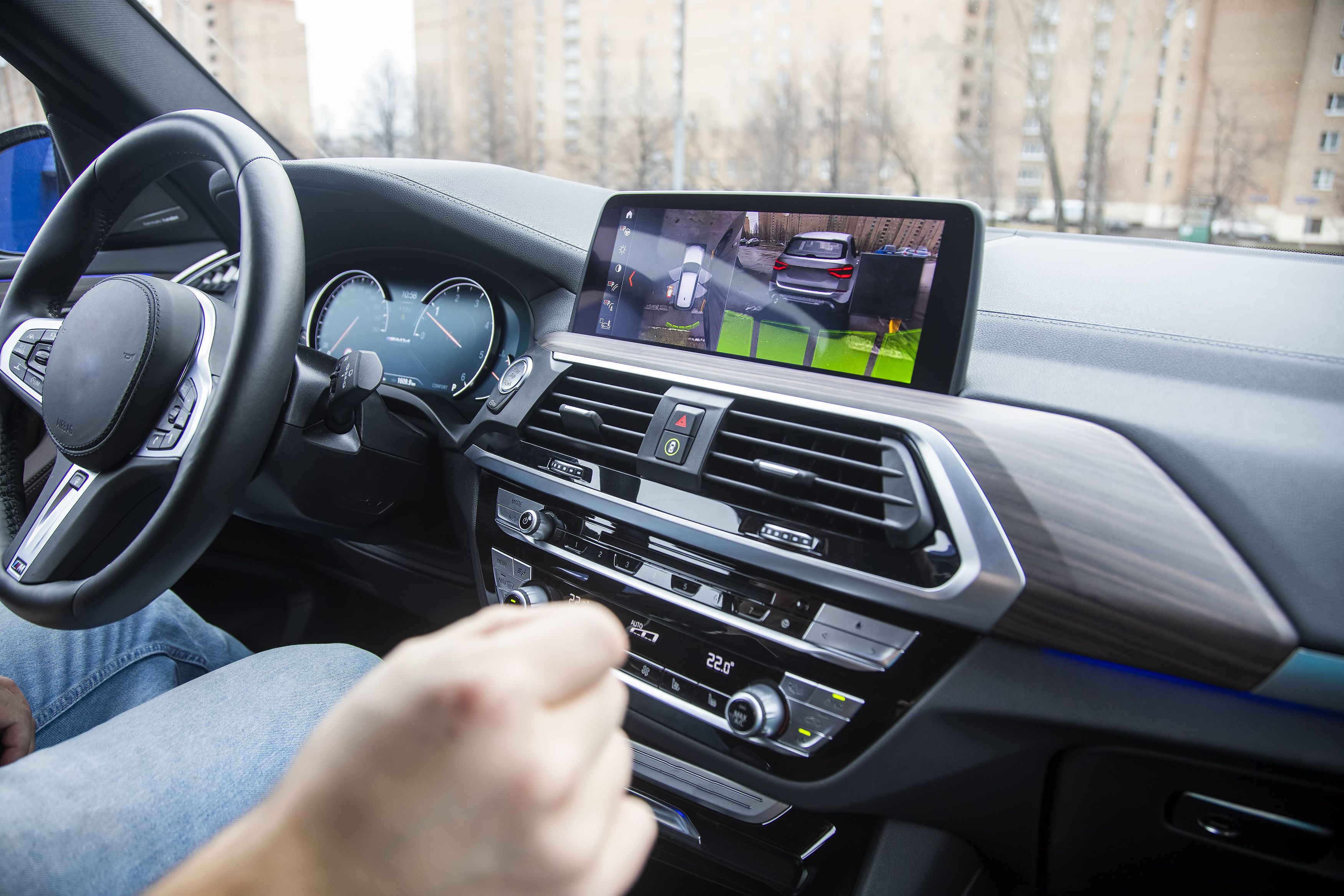 Bild zeigt einen Autofahrer in seinem Fahrzeug mit dem Bildschirm für die Autofunktionen.