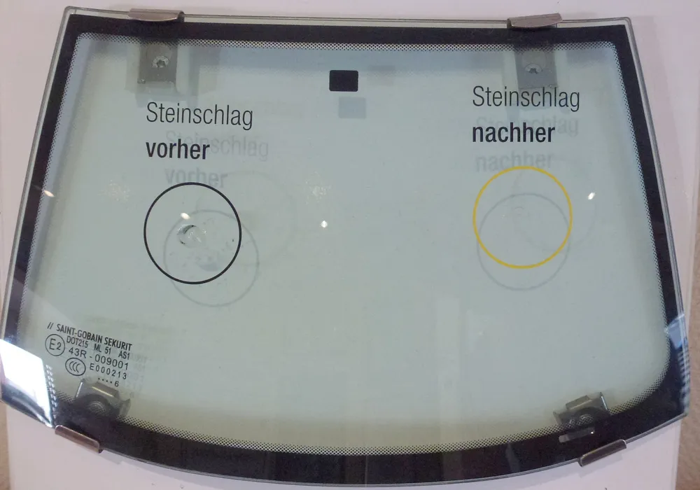 Auf dem Bild ist eine Autoscheibe zu sehen mit einen Steinschlag Schaden und einen reparierten Steinschlag Schaden.