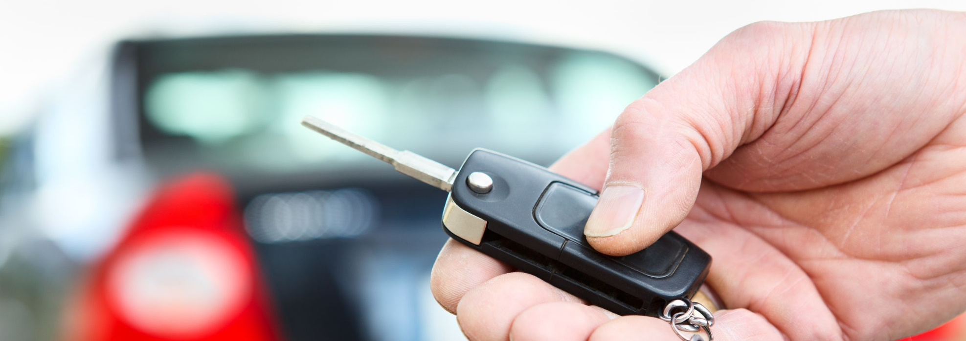 Bild zeigt eine Hand mit einem Autoschlüssel eines Mietwagens